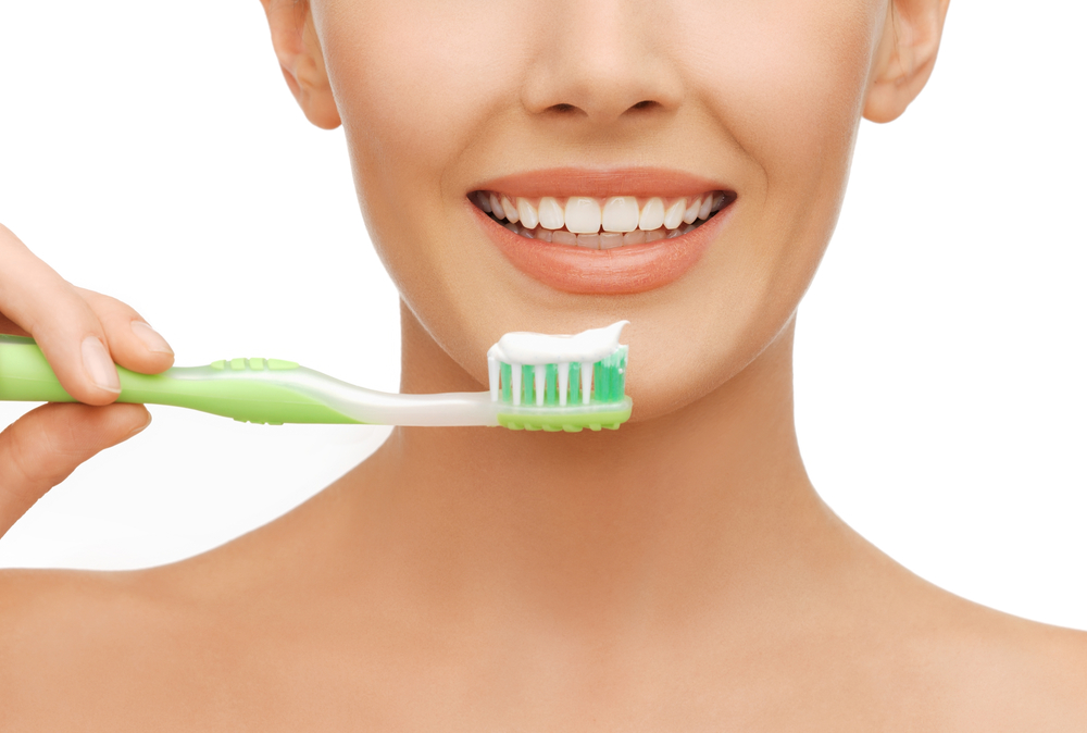 beauty and dental health concept - beautiful woman with green toothbrush